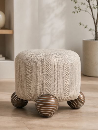 Beige knitted ottoman with spherical wooden legs.