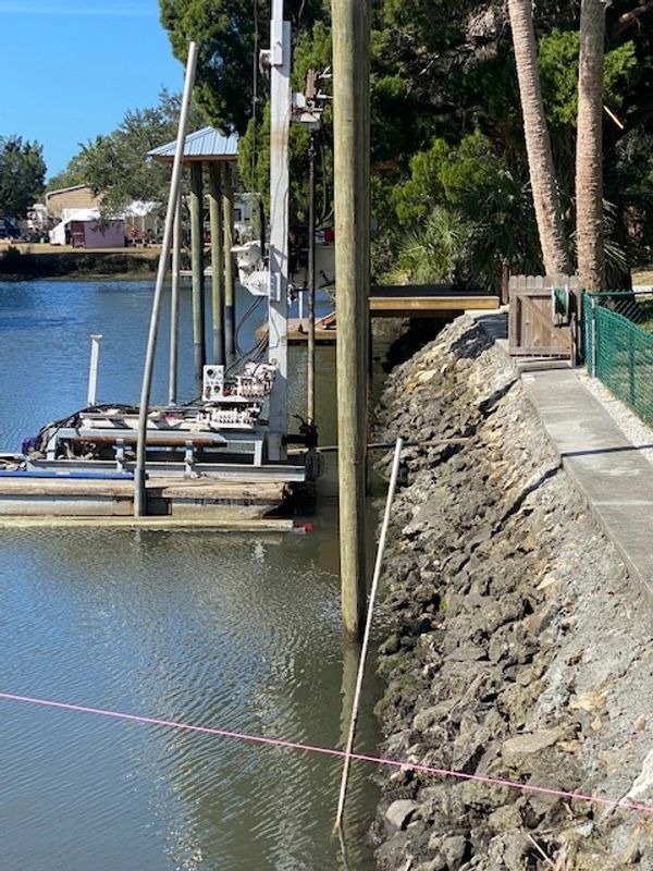 drilling pilings for a dock and boatlift along a rip rap seawall in Crystal River
