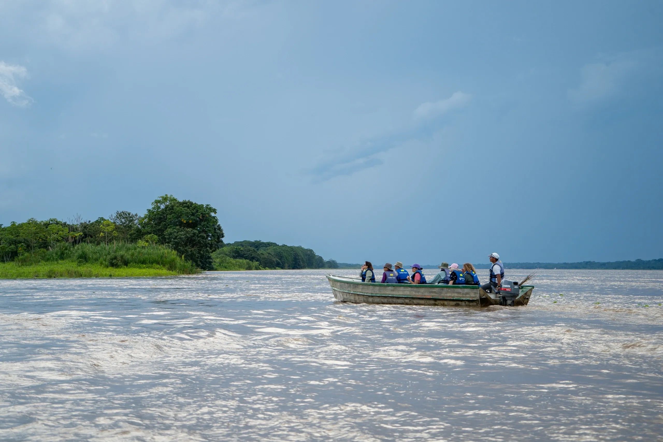 Río Amazonas - Iquitos, Perú, visitantes navegando en una embarcación por el paisaje amazónico.