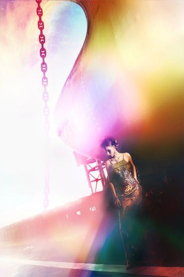 Woman in shimmering dress under colorful light and shadows.