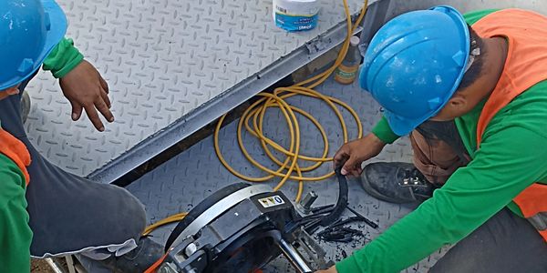 Workers fitting a pipe