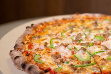 A pizza with chicken and green peppers.
