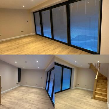 Modern empty room with large glass doors and wooden flooring.