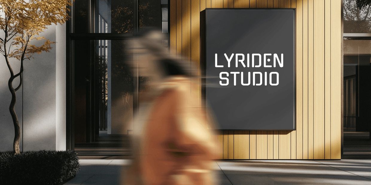 Blurred person walks past Lyriden Studio sign on wooden wall.