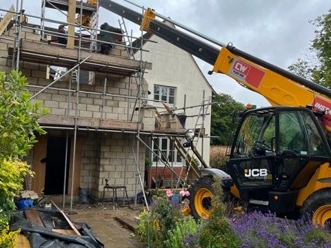 telehandler craning steals into double storey extension for roof. 