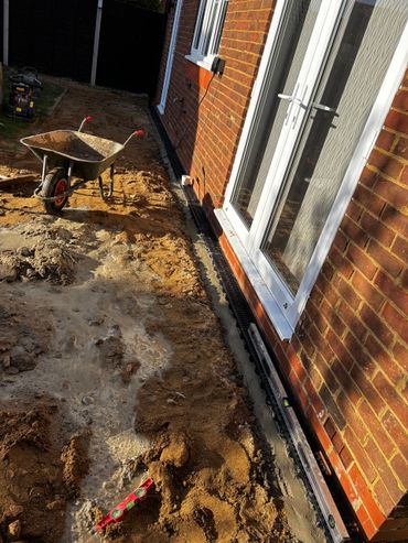 aco drains are in, existing sand has been scraped back revealing hardcore underneath. 