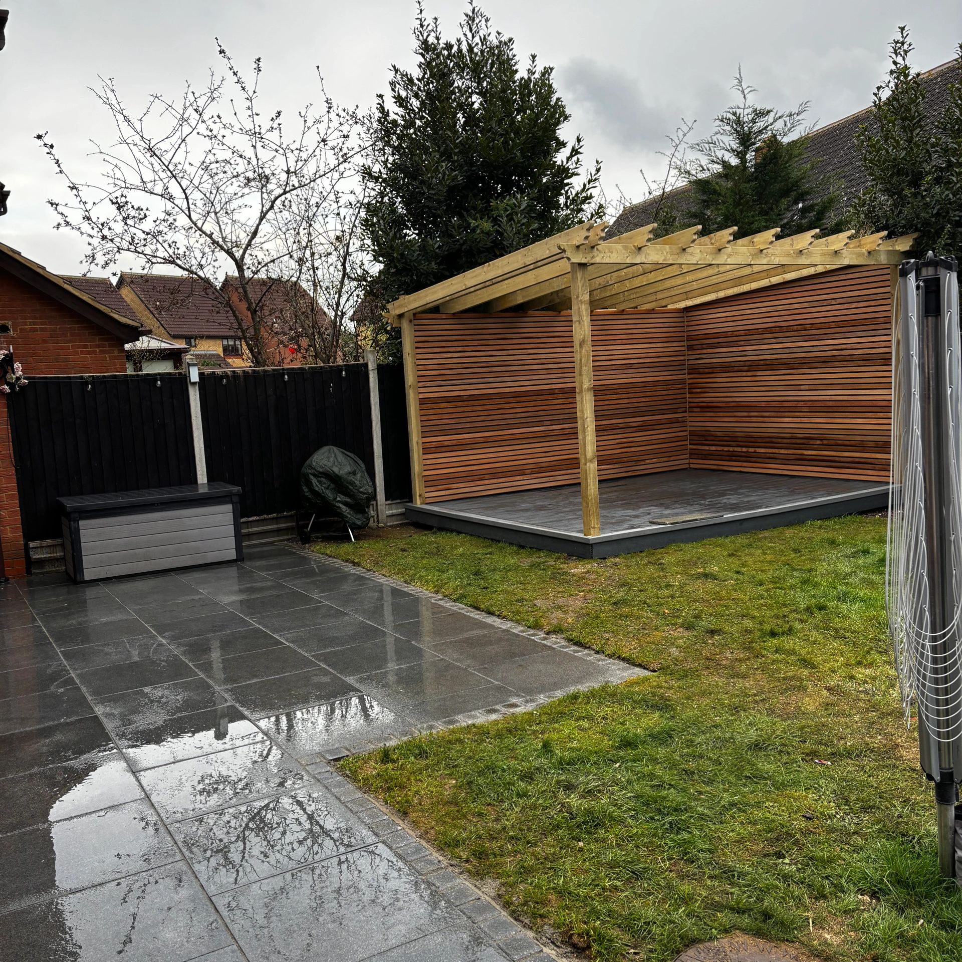 bespoke built pergola decking, using cedar slats and composite decking and freshly laid patio slabs. 
