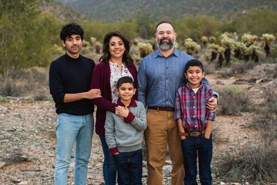 Happy family posing outdoors in a natural setting.