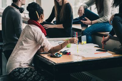 Group of people collaborating on a project around a table.