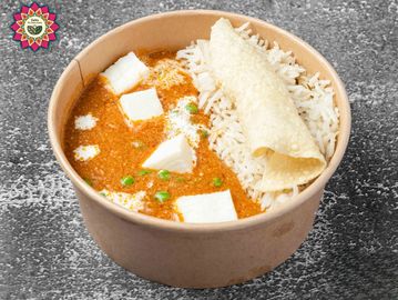 Indian meal with paneer curry, rice, and papad in a brown bowl.