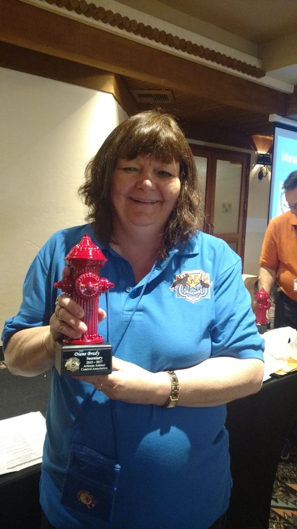 Woman holding a fire hydrant trophy and smiling