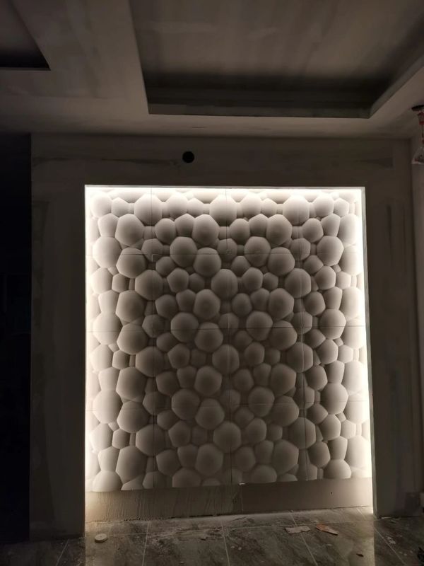 Backlit wall panel with a honeycomb-like 3D pattern in a dimly lit room.