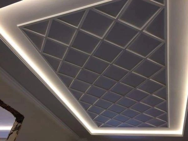Modern ceiling design with geometric patterns and LED lighting.