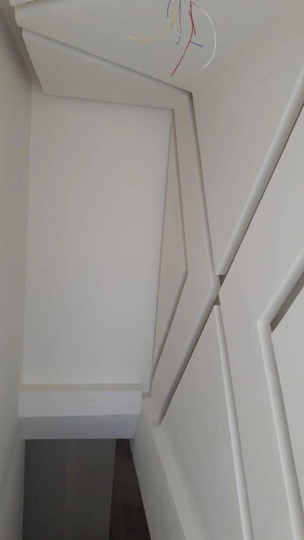 Modern ceiling design with geometric patterns and exposed wiring.