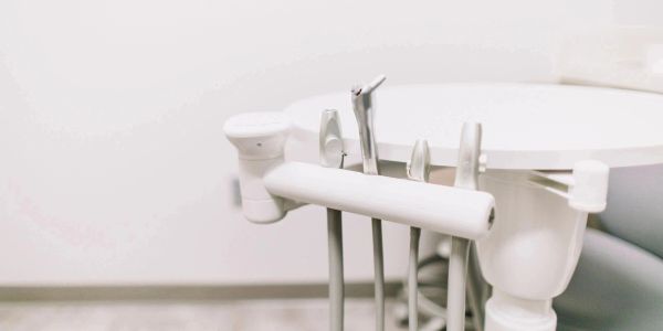 Close-up of dental tools on a white dental chair.