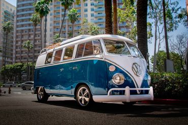 Blue and white classic Volkswagen van parked on a city street.