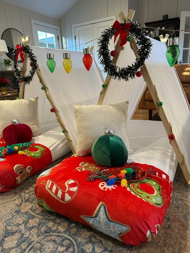 Cozy indoor Christmas-themed tents with festive pillows and decorations.