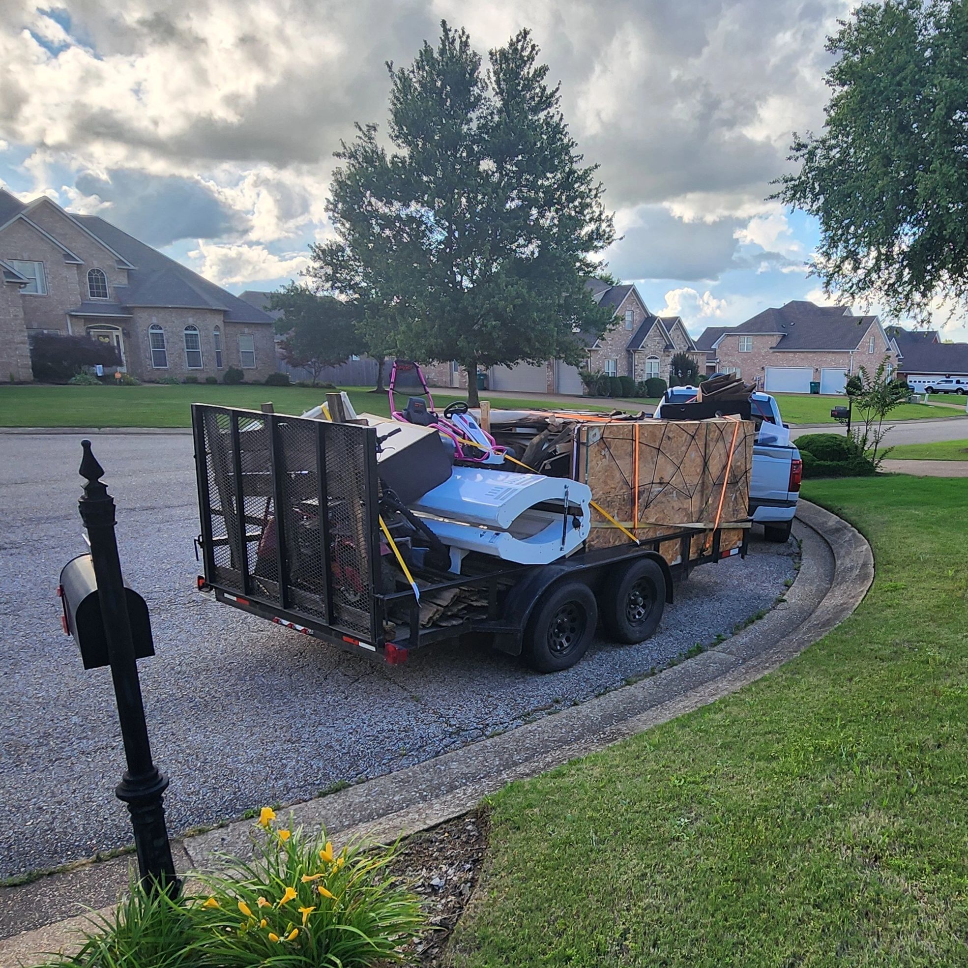 Trailer loaded with various items parked in a suburban neighborhood.