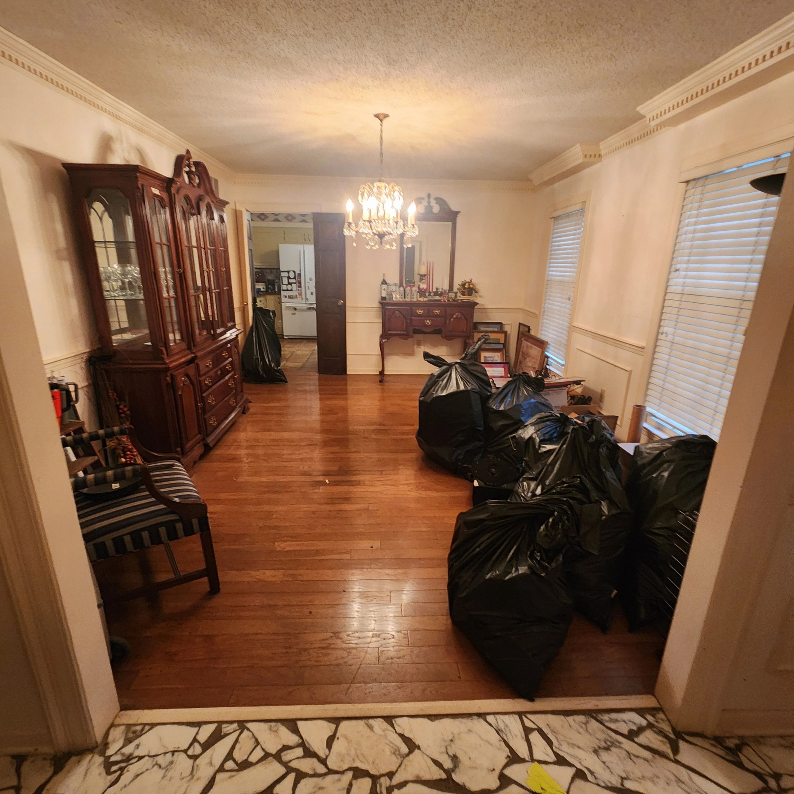 Dining room with wooden furniture and black trash bags.