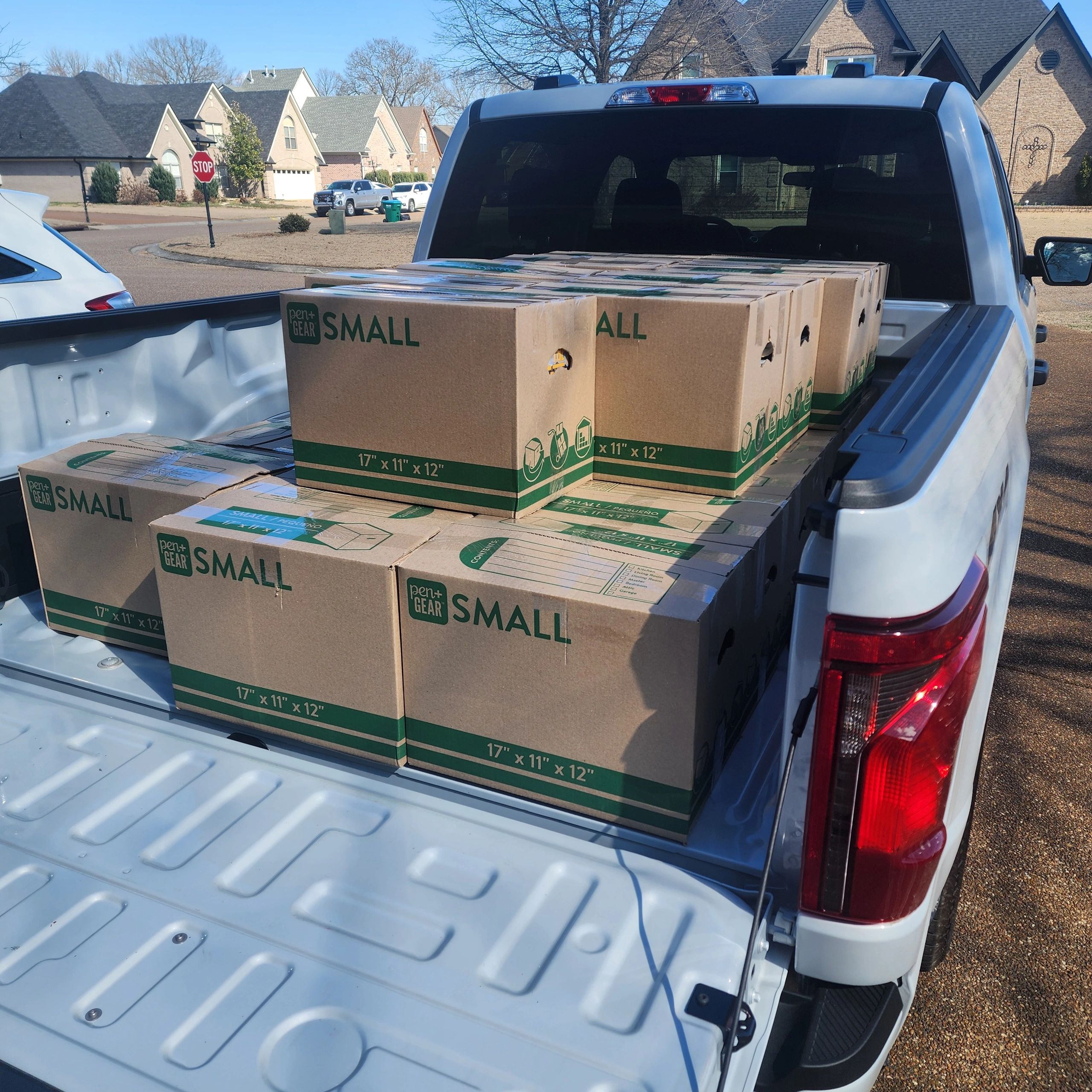 Boxes loaded in a truck bed in a residential area.