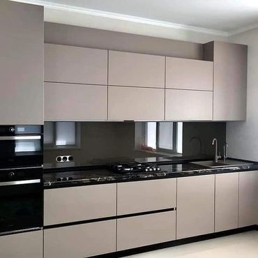 Sleek modern kitchen with beige cabinets and black marble countertop.