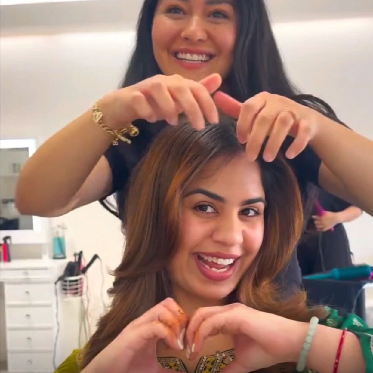 Smiling woman getting her hair styled at salon.