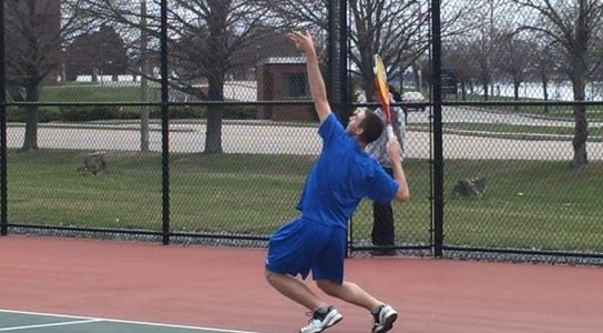 Coach Paul Braude practicing tennis serving