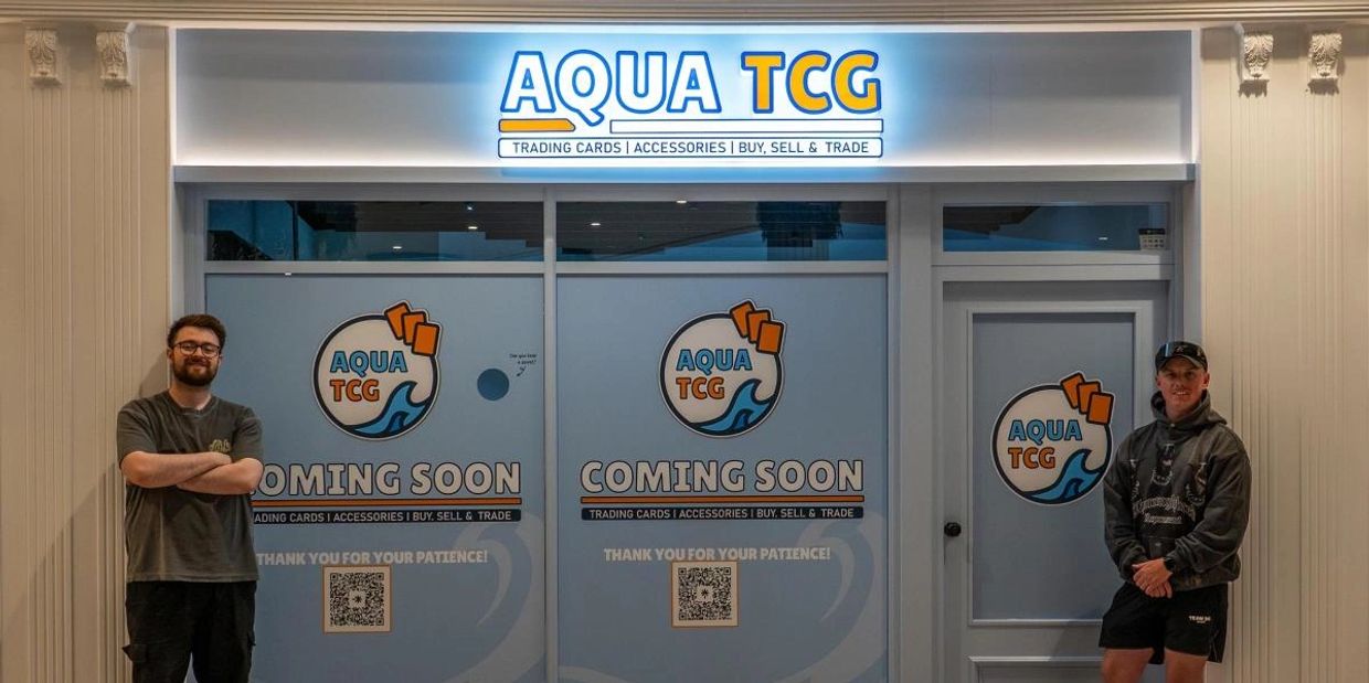 New Aqua TCG trading cards store coming soon with two men posing in front.