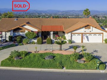 Single-story house with a tiled roof and landscaped front yard.