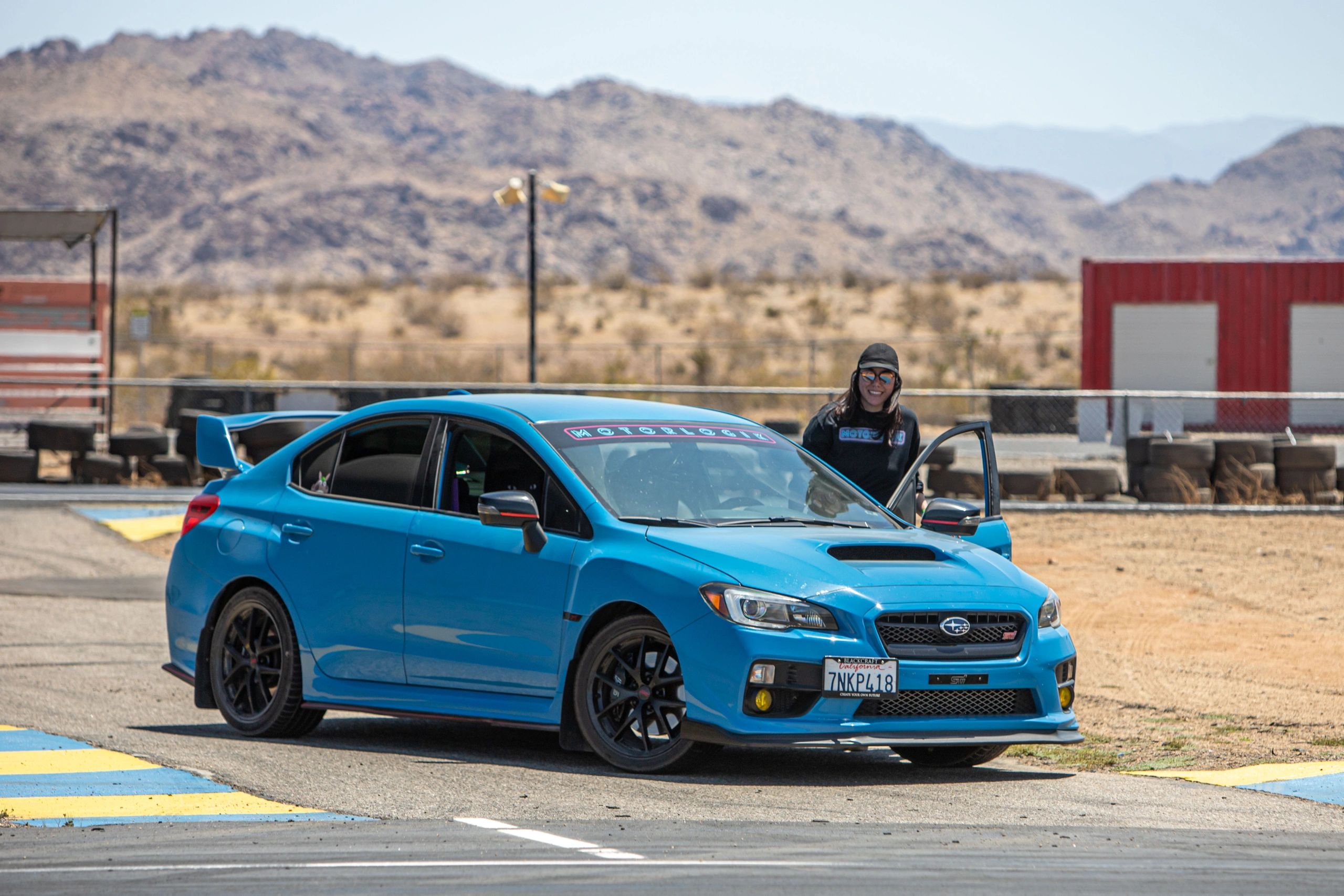 Driver posing next to a Subaru WRX STi
