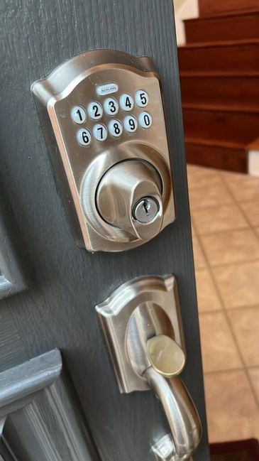Keypad door lock on a grey door.