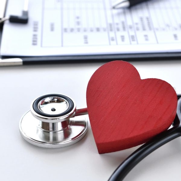 Stethoscope and wooden heart symbolizing heart health care.