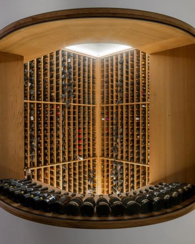 Elegant wine cellar with round entry and wooden racks.