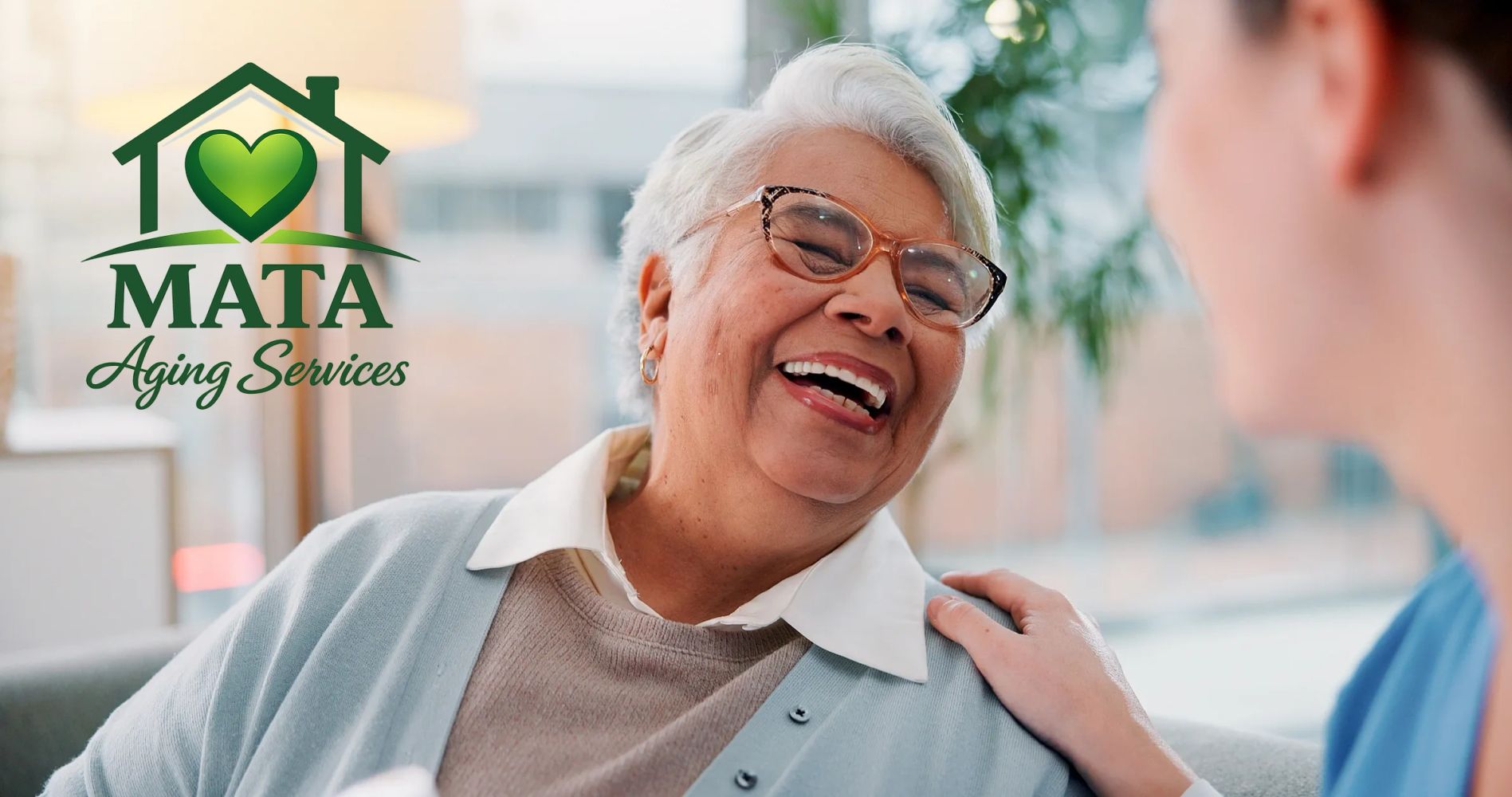 Elderly woman happily engaging with a caregiver, showcasing Mata Aging Services.