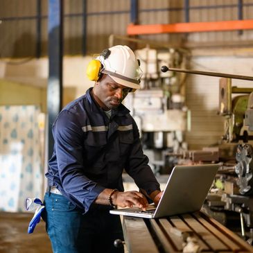 Técnico realiza diagnóstico en planta industrial con portátil, enfocado en mantenimiento de válvulas.