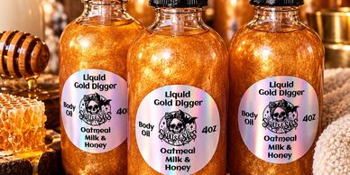 Bottles of Liquid Gold Digger body oil with oatmeal, milk, and honey.