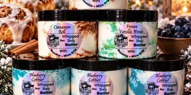 Jars of scented whipped body butter including Blueberry Cobbler and Cinnamon Roll.