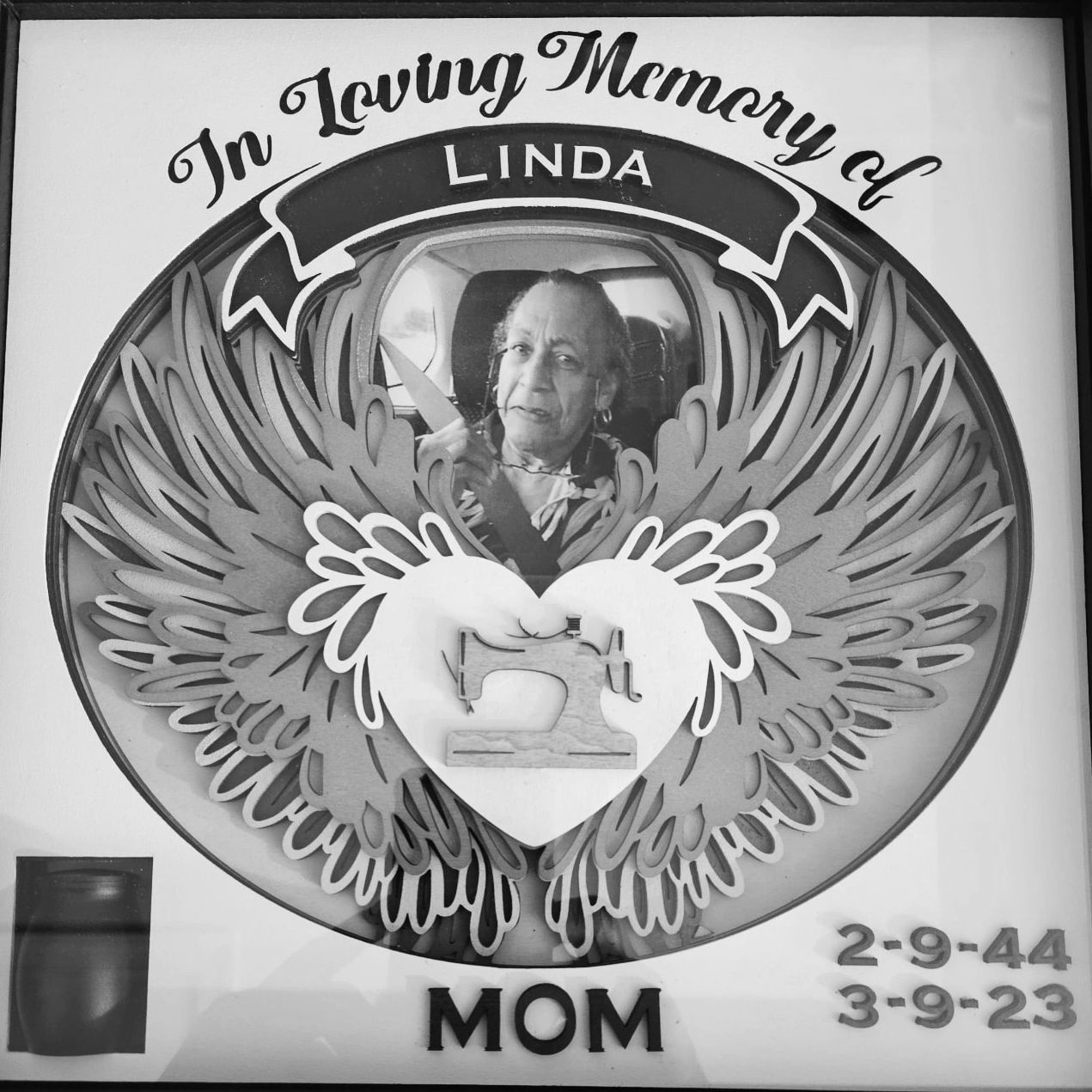 A memorial plaque with an image of a person in the center.