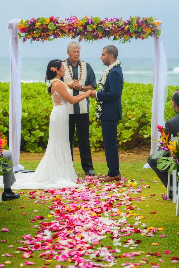 Kauai beach resort wedding tropical bright orange and red wedding flowers bamboo archAlohanas  