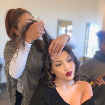 Photo of Tiara styling former paul Mitchell student Araceli’s hair in cosmetology school. 