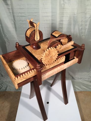 Intricate wooden mechanical model on a stand.