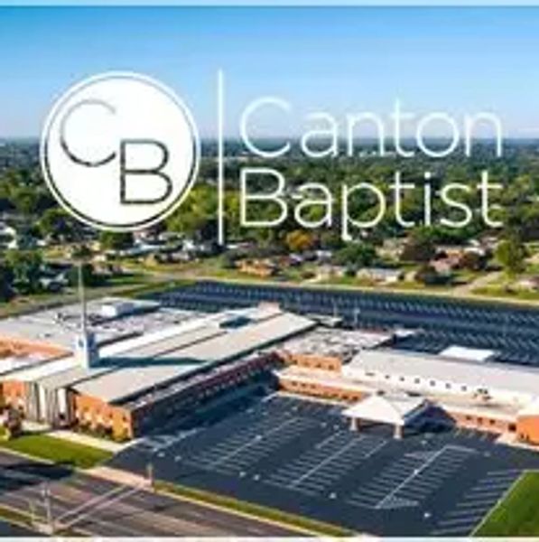 Aerial view of Canton Baptist building and parking lot under clear sky.