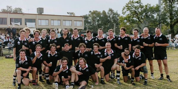 A rugby team posing together outdoors after a game.