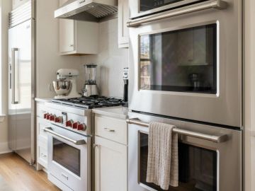 Modern kitchen with stainless steel appliances and white cabinetry.