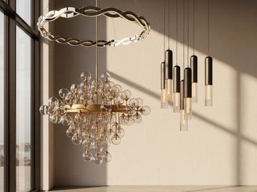 Modern chandeliers with glass and metal elements hanging in a sunlit room.