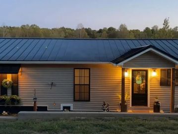 Cozy single-story house at dusk with warm porch lights.
