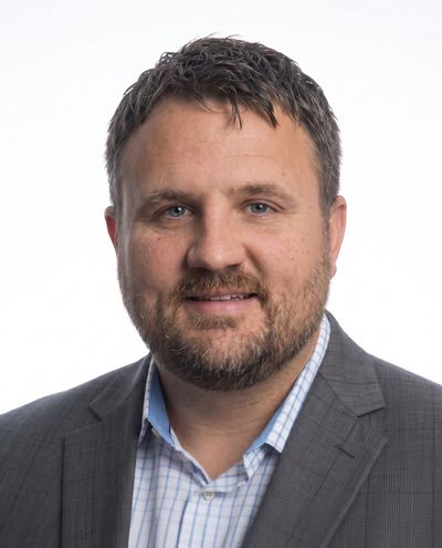 Portrait of a man in a suit with a beard.