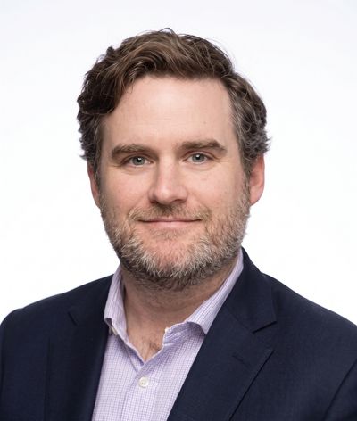 Man with beard in business attire.