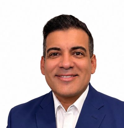 Man in a blue suit smiling at the camera.
