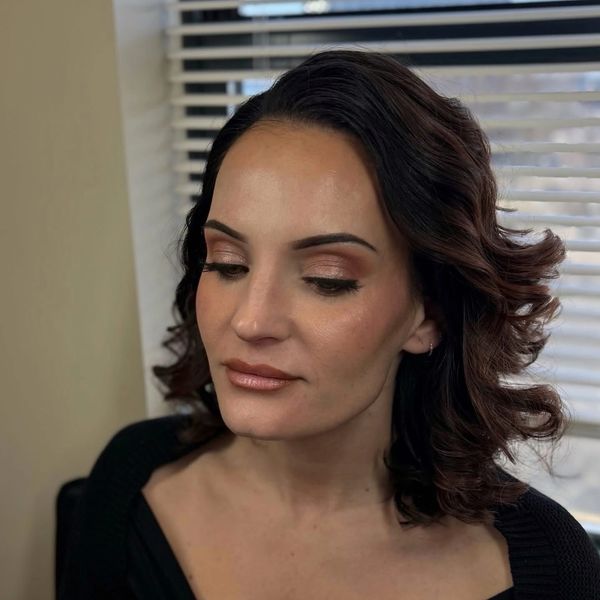 Woman with curled hair and natural makeup.